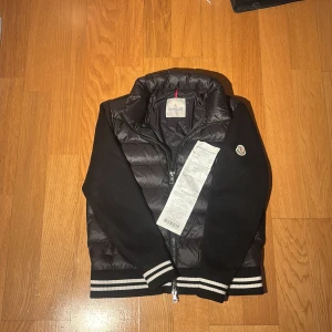 Moncler Cardigan - Tja! Säljer min Feta Moncler cardigan med kvitto från NK. Den är riktigt fet och är i strl 1 vilket motsvarar Small. Den har inga defekter! För mer frågor eller funderingar så hör av dig!