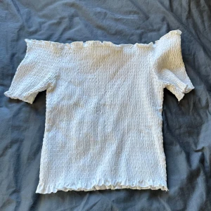 Vit offshoulder topp från H&M - Vit offshoulder tröja från hm. Storlek M. Ribbat stretchigt material. Säljer pga lite förstor. Skriv för bild på! Och pris kan diskuteras. 