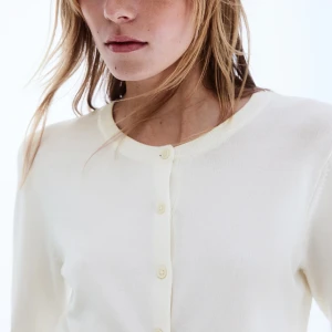 Vit kofta från H&M, XS - Klassisk vit kofta från H&M i storlek XS. Den har rund halsringning, långa ärmar🩵 det är ett litet hål på ena armen men det syns inte så mycket och det skulle lätt gå att sy ihop 🥰