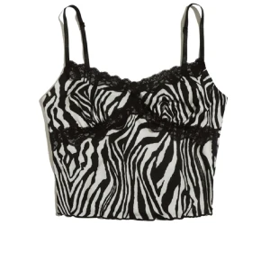 Zebramönstrad linnetopp  - Snygg zebramönstrad linnetopp från SHEIN med svarta spetsdetaljer längs bysten och tunna justerbara axelband. Toppen är i svartvitt och har en croppad passform som ger en trendig look. Perfekt att styla med jeans eller kjol för en cool vibe. Passar M 
