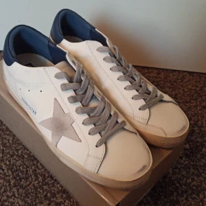 Golden Goose vita sneakers med grå stjärna - Helt nya par av golden goose, passade inte min storlek eftersom de var för små och kunde ej lämna tillbaka de. De är ett till ett och perfekt skick, de är den blåa vita färgen en av de mest populära och efterfrågade färgen.