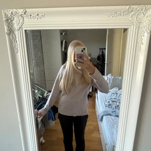 Beige/rosa stickad tröja - Mysig beige/rosa stickad tröja med rundad hals och ribbade muddar vid ärmslut och nederkant. Perfekt för dig som gillar enkel och clean stil. Passformen är normal och tröjan har långa ärmar. Snygg att matcha med svarta jeans eller kjol.