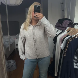 Beige stickad kofta från Saint Tropez - Mysig beige stickad kofta från Saint Tropez i storlek S. Koftan har långa ärmar, ribbade muddar och knappar framtill. 