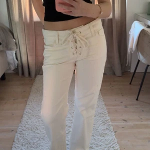 Vita jeans med knytning  - Säljer ett par vita raka jeans med snygg snörning framtill i midjan. Jeansen är lågmidjade🥰