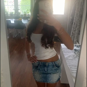 Lowwaist mini jeanskjol med pärlor - Snygg low waist mini jeanskjol i strl 25, midja:34 (har stretch). Kommer fler unika jeansshorts/kjolar så följ!!