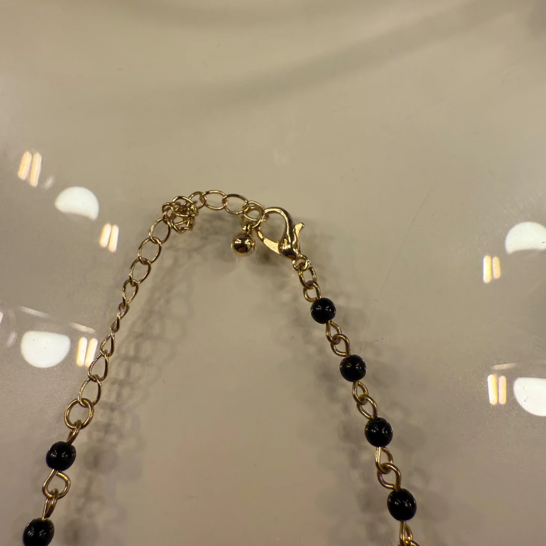 Guldigt halsband med svarta pärlor och berlocker - 2