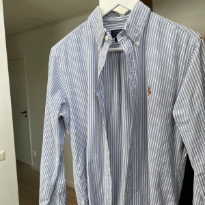 Blårandig skjorta Polo Ralph Lauren - Snygg blårandig skjorta från Polo Ralph Lauren i slim fit och  logga på bröstet. Storlek M men funkar även till S då den är slim fit. Pris går alltid att diskutera vid snabb affär. 