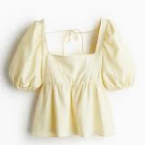 Gul blus med puffärmar och knyt - Superfin ljusgul blus med puffiga korta ärmar och söt knytning i ryggen. Blusen har en fyrkantig urringning och lätt volang nedtill som ger en romantisk vibe. Perfekt för varma dagar och ger en riktigt somrig känsla.