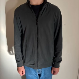 Grön zip-kofta - Massimo Dutti - Grön kofta från Massimo Dutti i storlek S. Stilren design med hel dragkedja framtill och ståkrage. Materialet är mjukt och känns som bomull, perfekt för lager-på-lager. Långärmad och passar till jeans eller chinos för en chill look. Modellen är 177 och väger cirka 64 kg! Hör av dig vid frågor! (Plagget skickas självklart inom 24 h efter det köpts)!