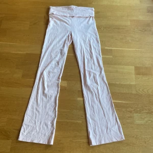 Ljusrosa mjukisbyxor från Gina Tricot - Supersköna ljusrosa mjukisbyxor från Gina Tricot med utsvängda ben och bred midja. Perfekta för en chill look och tillverkade i mjukt bomullsmaterial. Sitter snyggt och är riktigt bekväma att ha på sig.