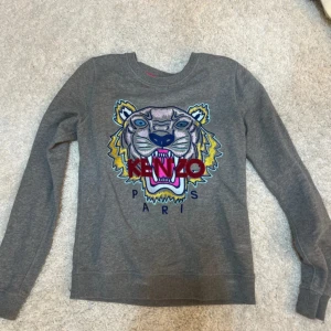 Grå Kenzo sweatshirt XS (äkta) - Säljer en grå äkta sweatshirt från Kenzo i storlek XS. Har tyvärr klippt bort skötselrådet 