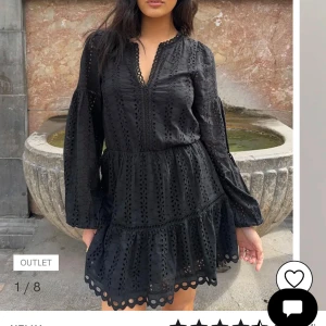 Svart broderad kortklänning från Nelly - Supersnygg svart klänning från Nelly med broderade detaljer och hålmönster. Modellen har långärmade puffärmar, v-ringad hals och volangkant nedtill. Perfekt för dig som gillar romantisk och trendig stil. Materialet är mjukt och känns skönt mot huden. Aldrig använd. Prislappen kvar. Ordinarie pris 599.