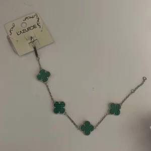 Grönt fyrklöverarmband - Aldrig använd. Färgen ska hålla i 3 år om den ej kommer i kontakt med parfym, kräm och handsprit tror jag