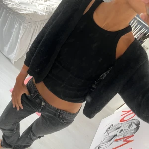 Svart stickad kofta från Cubus - Säljer en svart stickad kofta från Cubus i storlek M. Koftan har en öppen front utan knappar och är långärmad. Den är loose i passformen och gjord i ett mjukt stickat material som är perfekt att slänga över en topp. Enkel och stilren design som funkar till allt. Finns enstaka hål i den men syns inte 