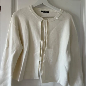 Vit stickad kofta med snörning Gina Tricot - Supersnygg vit stickad kofta från Gina Tricot i storlek S. Koftan har cool snörning framtill och rund halsringning. Långärmad och i mjukt stickat material som känns skönt mot huden. Perfekt för dig som gillar stilrena och trendiga plagg.