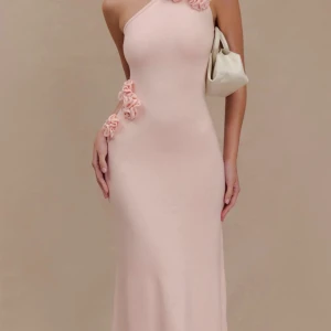 Ljusrosa långklänning med oneshoulder - Säljer en elegant ljusrosa långklänning med oneshoulder och figurnära passform. Klänningen har fina volangdetaljer längs axeln och sidan, vilket ger en unik och trendig look. 