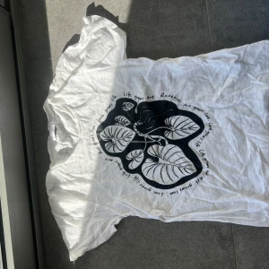 Vit Rodebjer linne t-shirt med tryck - Vit Rodebjer t-shirt av linne material med ett svart tryck av blad och text. T-shirten har en avslappnad passform och är kortärmad. Är en storlek xs men jag bär normalt small och passar perfekt. 