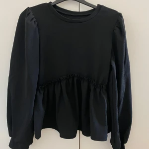 Svart långärmad topp  - Säljer en svart långärmad topp med volangdetaljer i midjan. Den är använd några gånger men fortfarande i perfekt skick💗