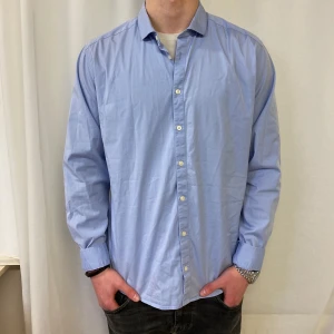  Tiger of Sweden skjorta  - Snygg blå skjorta från Tiger of Sweden i slim fit. Skjortan har långa ärmar och knappar framtill. Perfekt för en stilren look.