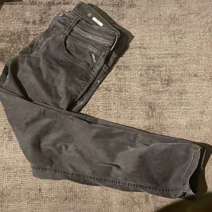 Svarta jeans från Replay - Snygga svarta jeans från Replay med klassisk femficksdesign och diskret logga på bakfickan. Perfekta för en stilren look.