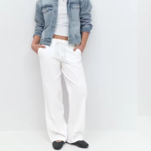 Vita linnebyxor med snörning - Säljer ett par vita linnebyxor med snörning i midjan. Byxorna har en loose passform och är perfekta för en avslappnad stil. De har fickor fram och en bakficka för extra funktionalitet.  Använda1-2 gånger