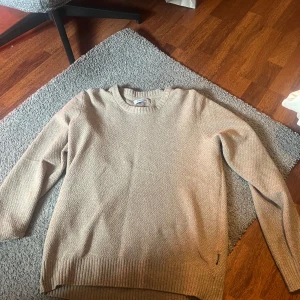 Beige tröja från Strömberg - Säljer en stilren beige tröja från Strömberg. Tröjan har en rund halsringning och är tillverkad i ett mjukt material med ribbade kanter vid ärmslut och nederkant. Perfekt för en avslappnad look.