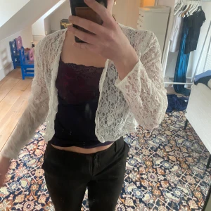 Vit spetskofta - Säljer en elegant vit spetskofta med långärmad design.