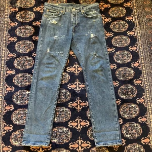 Blå jeans med slitningar - Riktigt snygga Levi’s byxor som jag gjort min egna design på, skulle man vela ha något mer på dom fixar jag gärna det efter betalning. Byxorna är använda va 5 gånger. Storlek 31W/32L. Passformen är perfekt straight fit. Vid frågor och funderingar hör gärna av er💯                                                                                Mvh Doré.reselll