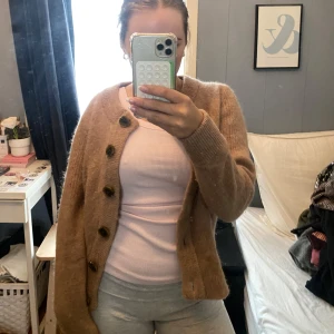 Brun kofta med knappar - Mysig brun kofta med stora knappar framtill. Perfekt för kyliga dagar. Långärmad och i ett mjukt material som känns skönt mot huden.