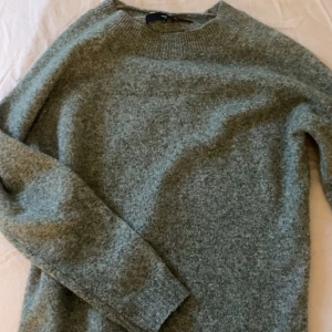 Grön stickad tröja från Vero Moda - Säljer en mysig grön stickad tröja från Vero Moda. Perfekt för kyliga dagar med sin mjuka och bekväma passform. Tröjan har långa ärmar och en rund halsringning. Passar utmärkt till både jeans och kjol. Storlek XS!🥰