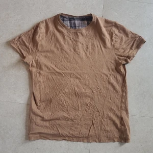 Brun t-shirt från Burton - Säljer en brun t-shirt från Burton Menswear med rund hals och korta ärmar. Storlek S för herrar, så för tjejer lite oversized eller stlk M.