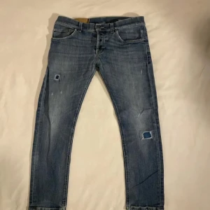 Dondup jeans - Snygga blå jeans med slitningar och en cool, avslappnad look. De har en klassisk femficksdesign och en knappgylf. Perfekta för en casual stil.