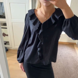 Svart blus med volangdetaljer - Säljer nu denna super fina svarta blusen som är helt oanvänd💓 Perfekt nu till sommaren och vardagen 💗 Skriv vid funderingar 