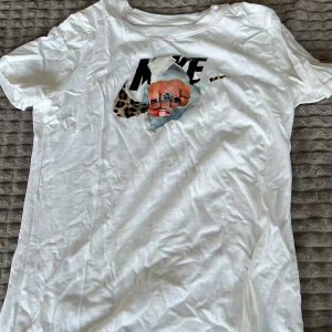 Vit t-shirt med leoparddetalj - Säljer en cool vit t-shirt med ett unikt tryck av en person med glasögon och leopardmönster. Perfekt för dig som vill sticka ut! 🐆