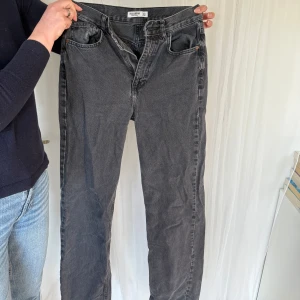 Svarta jeans från Pull&Bear - Snygga svarta jeans från Pull&Bear i en klassisk rak stil. De har en dragkedja och knapp framtill samt fem fickor. Perfekta för en avslappnad look.