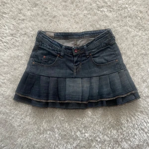 Jeanskjol från Lee - En lågmidjad jeanskjol omsydd från ett par jeans. Midjemått tvärsöver - 39cm Längd - 35 cm