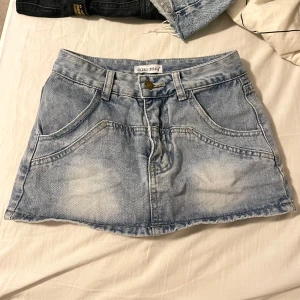 Lågmidjad jeanskjol - Säljer en snygg lågmidjad blå jeanskjol med insydd byxdel. Väldigt fin till sommaren men säljer då den är för liten för mig. OBS! Det är storlek XS men den är liten i storlek.