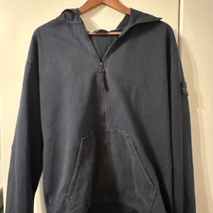 Stone Island zipped hoodie - Mörkblå Stone Island hoodie i lite större M. Mörkblå patch i relativt bra skick. Köpt från Stone Islands hemsida. 