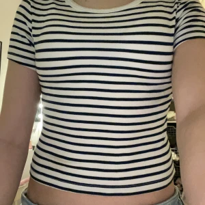 Randig kortärmad topp från Zara - Säljer en stilren randig topp från Zara i vitt och mörkblått! Har nästan aldrig använt och är i strl xs. Superfin och sååå mjukt material!!💗❤️