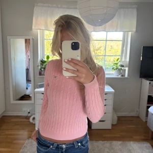 Rosa kabelstickad tröja från Gant - Säljer en ljusrosa kabelstickad tröja från Gant med logga på bröstet. Tröjan har rund hals, ribbade muddar och är långärmad. Tröjan är i barnstorlek men sitter som en xs/s💕