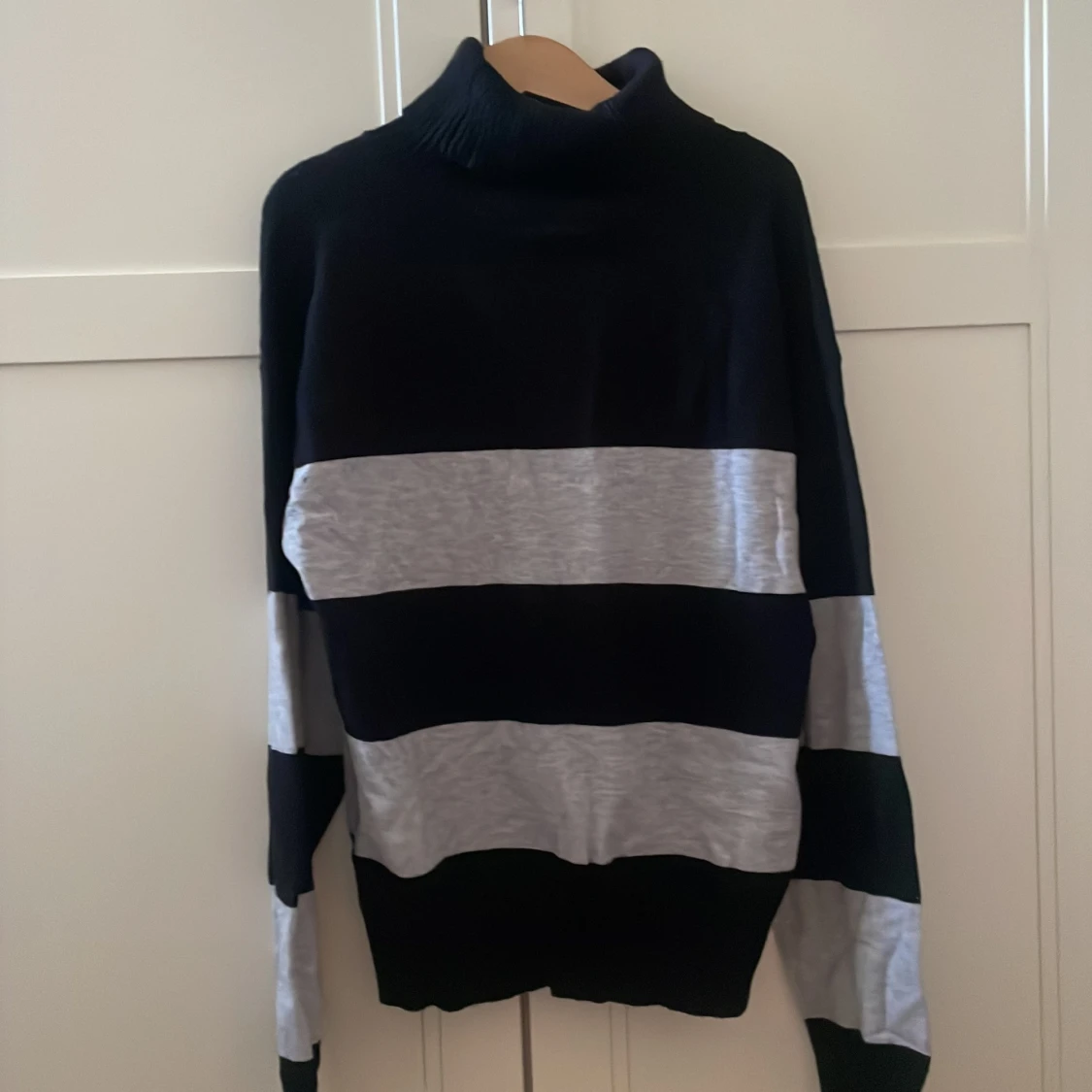 En grå/svart randig crewneck 