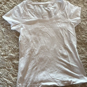 Vit t-shirt från laget 157 med rund hals - En enkel och fräsch vit t-shirt från 157 i storlek XS. Modellen har rundad hals och korta ärmar, perfekt för en clean och chill look. Tillverkad i mjuk bomull med lite stretch för skön passform. Passar dig som gillar basic och stilrent. Oanvänd,