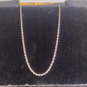 Tvinnad halskedja i silver - Snygg halskedja med tvinnad design i silverfärg. Kedjan har en klassisk och stilren look som passar perfekt till din vardagsstil. Den är tunn och smidig, vilket gör den enkel att bära och kombinera med andra smycken. Halsbandet är inte i riktigt silver men är gjord av stål.