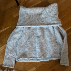 Ljusgrå stickad polotröja Gina Tricot - Supermysig ljusgrå stickad polotröja från Gina Tricot i storlek S. Tröjan har en bred, ribbad polokrage och långa ärmar. Perfekt för kyliga dagar och enkel att matcha med jeans eller kjol. Materialet är mjukt och ger en chill vibe.