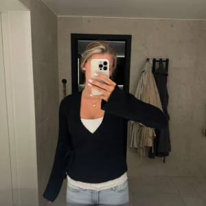 Svart omlottkofta med knyt - Svart omlottkofta knyt i sidan. Koftan är stickad och i storlek S från Gina Tricot. Använd fåtal gånger