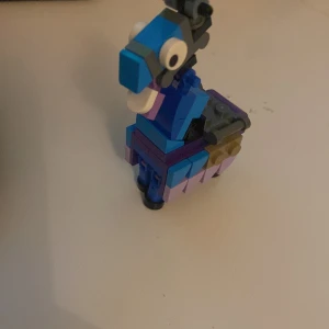 Lego lama  - Ingen bok syns på bilderna, endast en färgglad LEGO-figur som liknar en lama. Om du letar efter böcker, vänligen ladda upp bilder på bokomslag eller bokens sidor.