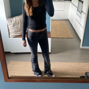 Svarta bootcut jeans - Säljer ett par svarta jeans med bootcut passform och låg midja. Jeansen har klassisk femficksdesign och är tillverkade i ett stretchigt denimtyg som sitter snyggt och bekvämt. Perfekta för dig som gillar en tidlös och cool stil.