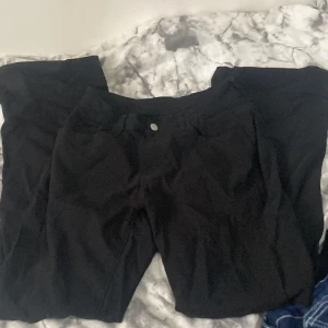 Svarta byxor i viscose, storlek S - Svarta byxor i mjukt material med klassisk femficksdesign och knappstängning fram. Tillverkade av 77% viscose och 20% polyamid, vilket gör dem sköna och följsamma. Passar dig som gillar stilrena och enkla byxor med rak passform. Från SHEIN