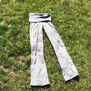 Grå mjukisbyxor från Gina Tricot - Supermjuka grå mjukisbyxor från Gina Tricot med bred, ribbad midja som kan vikas ner. Byxorna har raka, lite vidare ben och är gjorda i ett stretchigt bomullsmaterial som är riktigt skönt mot huden. Perfekta för chill eller träning.