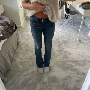 LTB Valerie jeans med slitningar - Säljer ett par blå lågmidjade bootcut jeans från ltb modell valerie. Jeansen har slitningar och hål vid knäna. Midjemått: 37 Innerbenslängd: 83